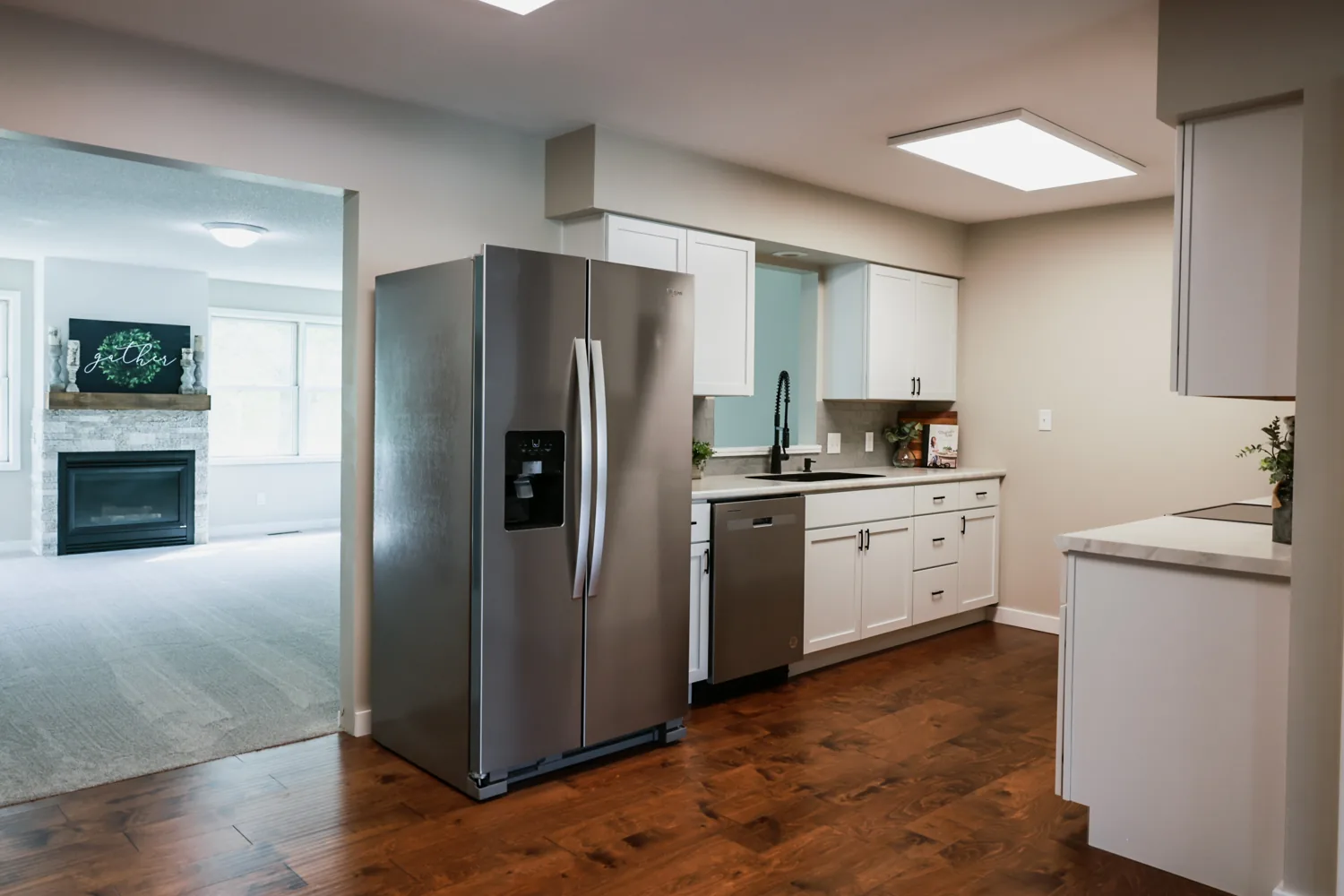 Completed interior painting project featuring a bright kitchen with neutral walls and white cabinetry